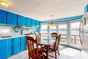 a kitchen with blue cabinets and a table with chairs at Oyster Lane Hideout in Ocean City