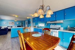 a kitchen with a wooden table and blue cabinets at Oyster Lane Hideout in Ocean City
