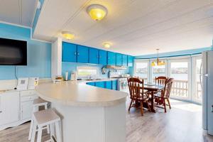 a kitchen with blue cabinets and a table and chairs at Oyster Lane Hideout in Ocean City