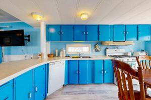 a blue kitchen with blue cabinets and a sink at Oyster Lane Hideout in Ocean City +28 photos