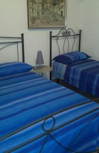 ガリポリにあるVilla Graziellaのベッドルームに青いシーツが備わるベッド2台