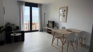 a living room with a table and chairs and a television at Canelas 22 in Sanxenxo