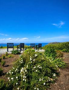 two benches sitting on a path looking at the ocean at Minch View Cabin 2, 1 Earlish in Earlish