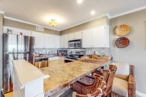 a kitchen with white cabinets and a large counter top at Our Place At The Beach 206B in Ocean City