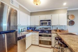 a kitchen with white cabinets and stainless steel appliances at Our Place At The Beach 206B in Ocean City