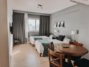 a hotel room with two beds and a table at Gran Hotel Buenos Aires in Buenos Aires +59 photos
