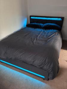a bed in a bedroom with blue lights on it at Private Hydro Spa Pool, Dbl Bedrm & Bathrm - Other areas part private shared lived-in home in Bickershaw