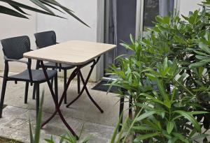 a wooden table and two chairs next to some plants at Vele House Walk to Beach in Herceg-Novi