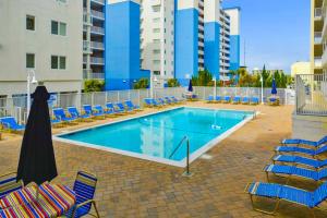 a swimming pool with lounge chairs and a hotel at Purnell House 402 in Ocean City