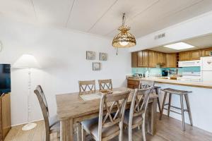 a kitchen with a wooden table and chairs at Purnell House 402 in Ocean City +20 photos