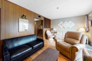 a living room with a leather couch and a chair at Gullway Getaway in Ocean City