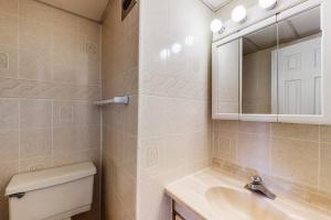 a bathroom with a toilet and a sink and a mirror at Gullway Getaway in Ocean City