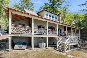a house with a large deck and a staircase at WeSeekANook in Meredith