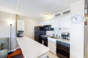 a kitchen with white cabinets and a black refrigerator at Atlantis 502 in Ocean City