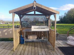 a wooden gazebo with a stove on a deck at Glamping Bell Tent in Norton Saint Philip +4 photos