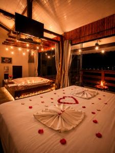 a bedroom with two beds with roses on the bed at Refugio nas Alturas LANDIN & CHARM in Santo Antônio do Pinhal