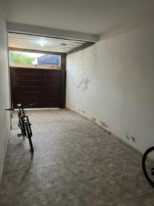 a bike parked in a garage with a garage door at Quarto família ap5 in Montes Claros +9 photos