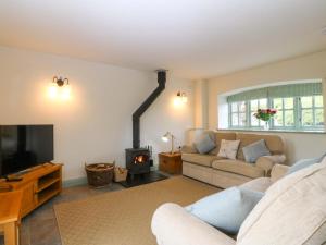 a living room with a couch and a fireplace at No 2 The Stables in Llangefni