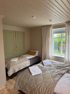 a bedroom with two beds and a window at Downtown Boutique Apartment in Akureyri