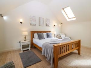 a bedroom with a large bed with towels on it at No 2 The Stables in Llangefni