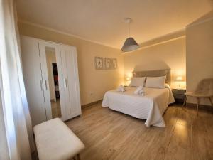 a bedroom with a white bed and a chair at Casa Papel y Pluma in Cazorla