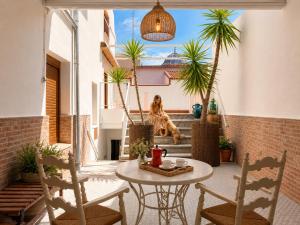 a patio with a table and chairs and a dog at Las 9 Candelas alojamiento en el centro de Yecla in Yecla