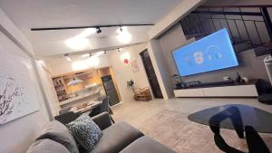 a living room with a couch and a flat screen tv at CHL Pod in General Trias