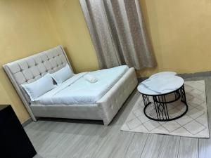 a bedroom with a white bed and a table at Rosebank Villas in Luanda