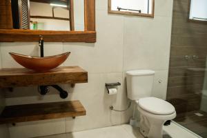 a bathroom with a bowl sink and a toilet at Pousada Quinta do Cangueri in Imaruí
