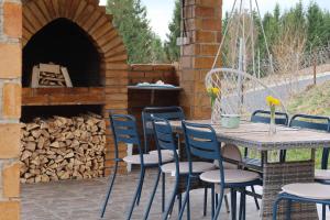 a table and chairs in front of a brick oven at Vila Haiduk in Runcu