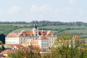 a large white building with red roofs on a hill at Apartmány LISON in Valtice