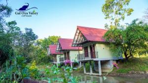 a house with a red roof in a garden at Gal Oya Valley Cottages in Ampara +17 photos
