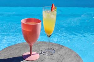 two drinks sitting on a table next to a pool at Villa Linnea in Hanko