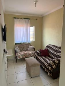 a living room with a couch and a window at Casa no pavimento superior in São Luís