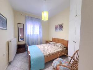 a small bedroom with a bed and a window at An-Mary by vacapers in Iraklitsa +3 photos