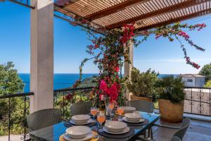 a table on a balcony with a view of the ocean at Apartments Oktopus in Sutomore