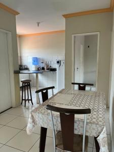 a kitchen with a table and some chairs and a table and a kitchen at Casa no pavimento superior in São Luís +5 photos
