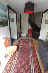 a living room with a red chair and a rug at La Haute Flourie - bed and breakfast -chambres d'hôtes in Saint Malo