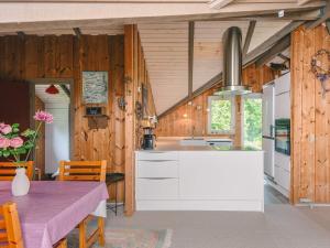 a kitchen with white cabinets and a table with a purple tablecloth at 6 person holiday home in Oksbøl in Oksbøl