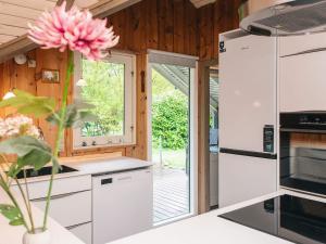 a kitchen with white appliances and a pink flower in a vase at 6 person holiday home in Oksbøl in Oksbøl
