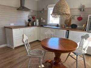 a kitchen with a wooden table and chairs and a sink at Villa Emma in Alsterbro +35 photos