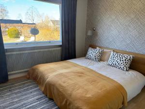 a bed in a bedroom with a large window at Villa Emma in Alsterbro