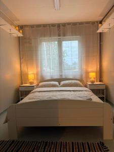 a bedroom with a large bed with two night stands at Namiņš in Ragaciems