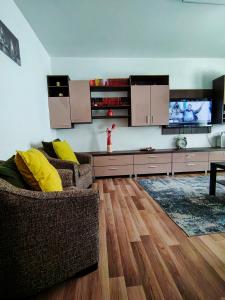 a living room with two chairs and a flat screen tv at Adrian Home Mega in Ploieşti