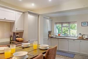 a kitchen with a wooden table with glasses of orange juice at 2 Bed in Cherry Burton oc-c37535 in Cherry Burton