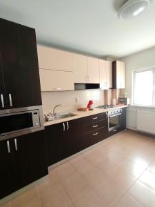 a kitchen with black and white cabinets and a window at Adrian Home Mega in Ploieşti +10 photos