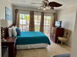 a bedroom with a blue bed and a balcony at Coconut Cove Resort & Marina in Islamorada +86 photos