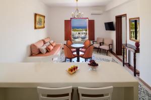 a kitchen and living room with a table and chairs at Kaminia Holiday Homes in Éxo Goniá