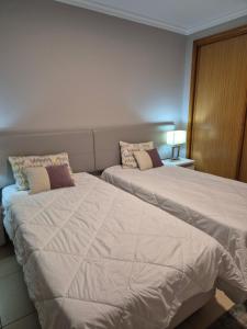 two beds sitting next to each other in a bedroom at CARAVELL ARMAÇÃO de PÊRA in Armação de Pêra