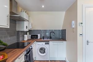 a kitchen with a washer and dryer at Premium Apartment Steps from Wembley Park in London